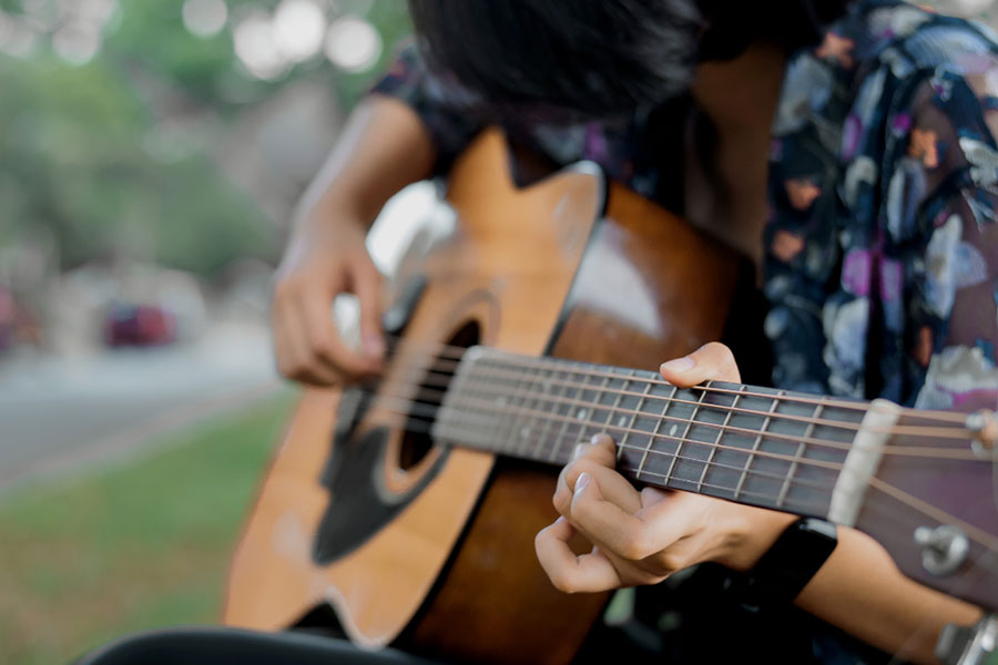 Closeup of a person playing guitar.