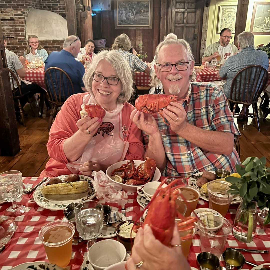 lobsterInset A couple at a Lobster Feast holding up their lobsters.