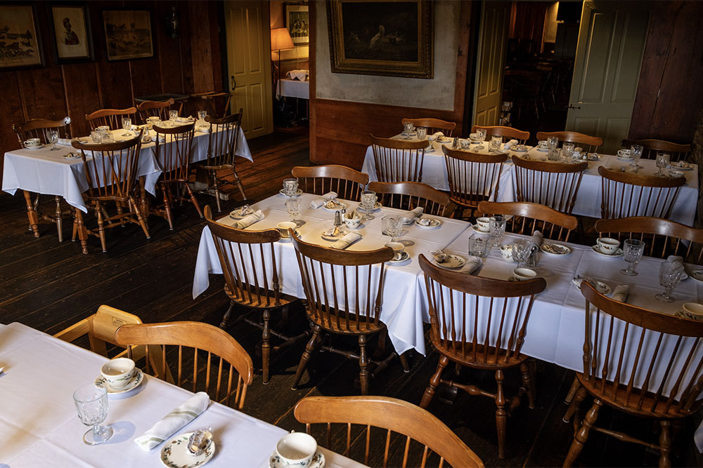 Tavern-room A shot of the Tavern Room with tables set with tablecloths, glasses, and place settings.
