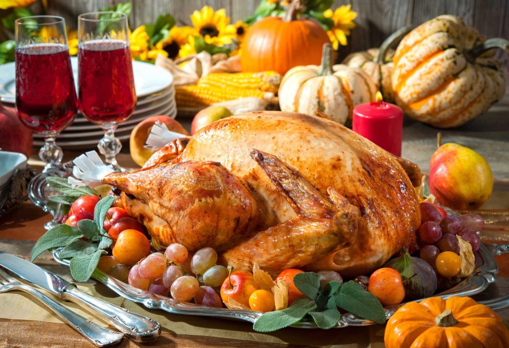 Closeup of a Thanksgiving turkey with harvest centerpieces.