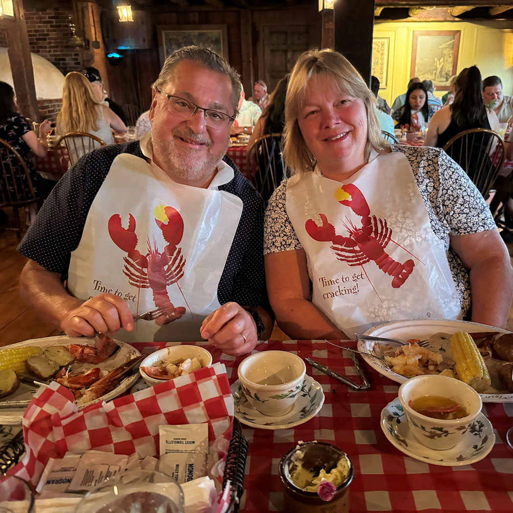 lobsterFeastInset2 Closeup of a couple enjoying the Lobster Feast wearing lobster bibs.